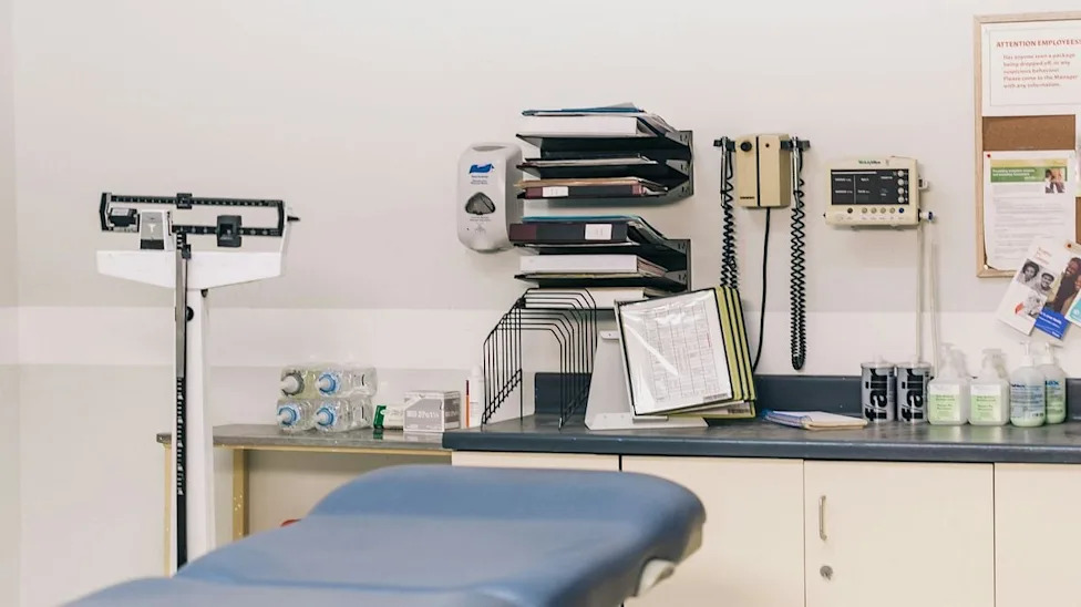 A medical exam room with an exam table, diagnostic tools and a weight scale. Photo: Shopify Partners / Burst